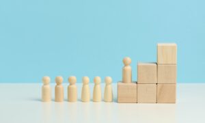 Wooden figures of men on a ladder made of blocks.